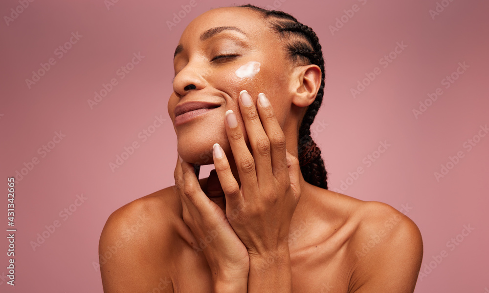 Woman using moisturizer on her face
