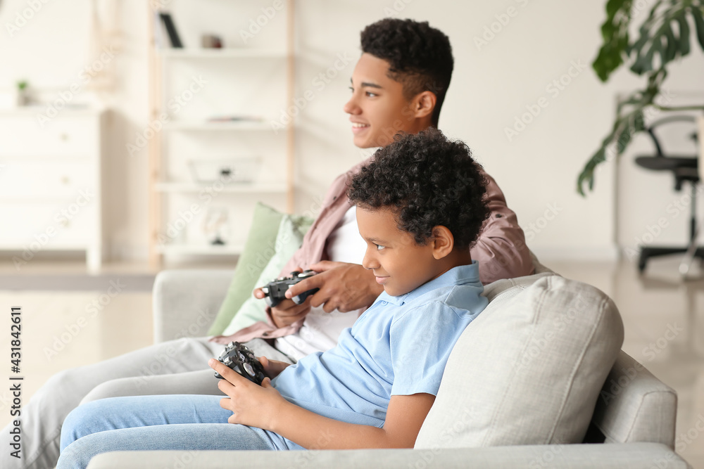 非裔美国男孩在家玩电子游戏
