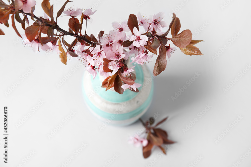 灰色背景上有美丽的开花树枝的花瓶