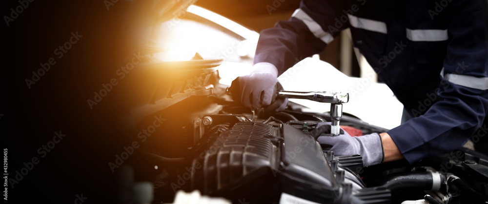 汽车修理工在修理厂修理汽车发动机。维修服务，汽车服务，修理，保养
