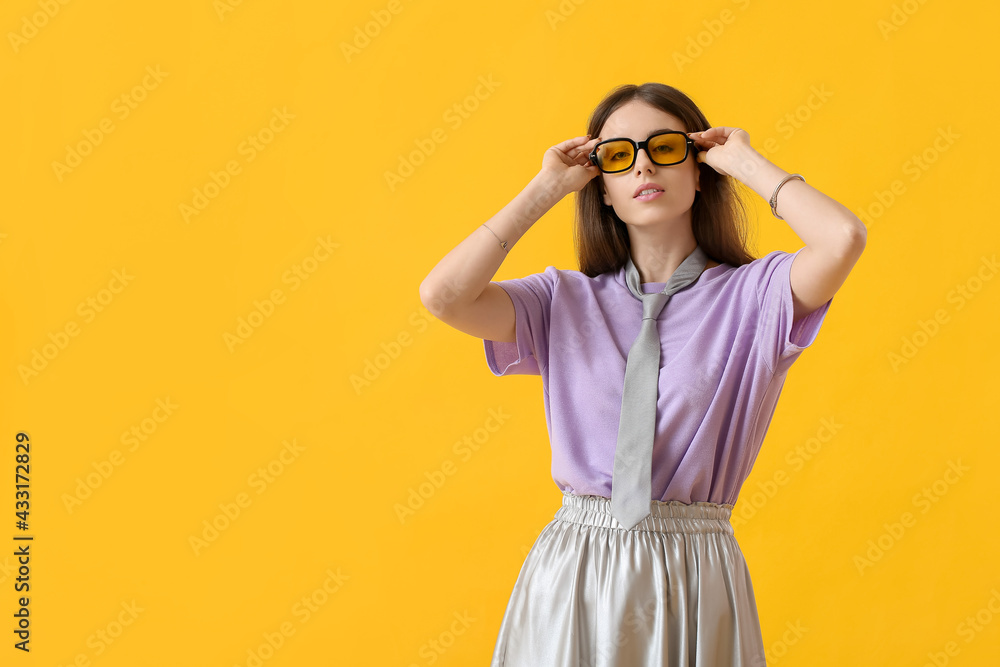 美丽的年轻女人，带着时尚的太阳镜，背景是彩色