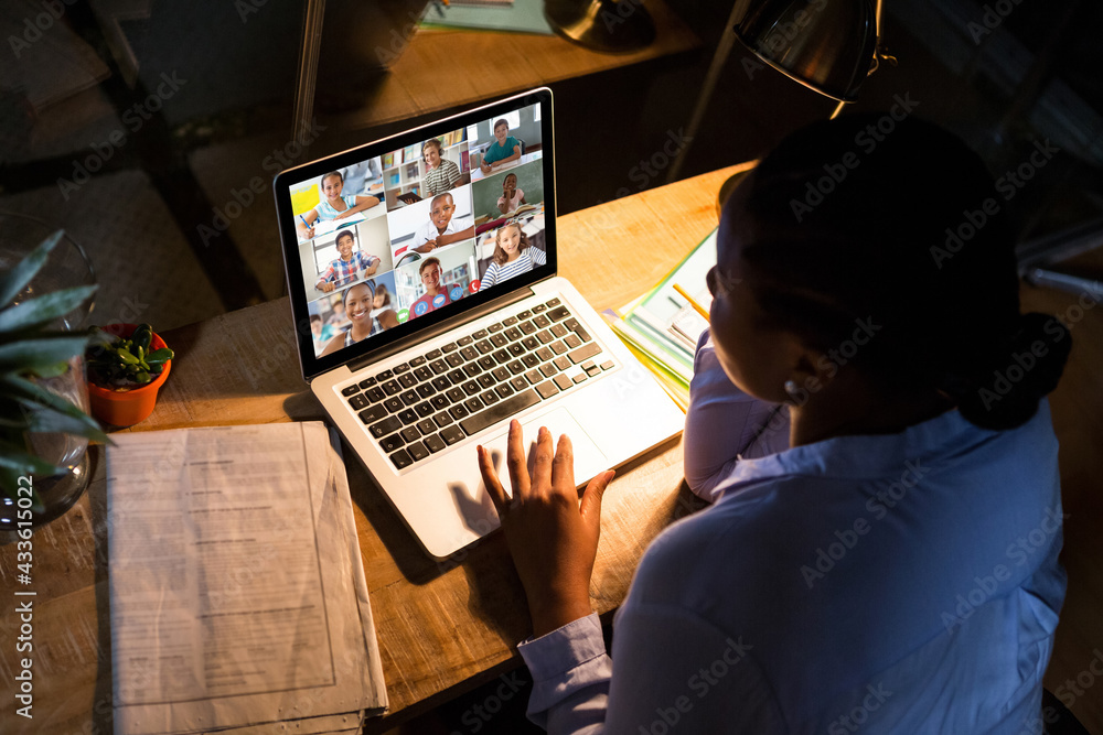 African american businesswoman sitting at desk using laptop having video call