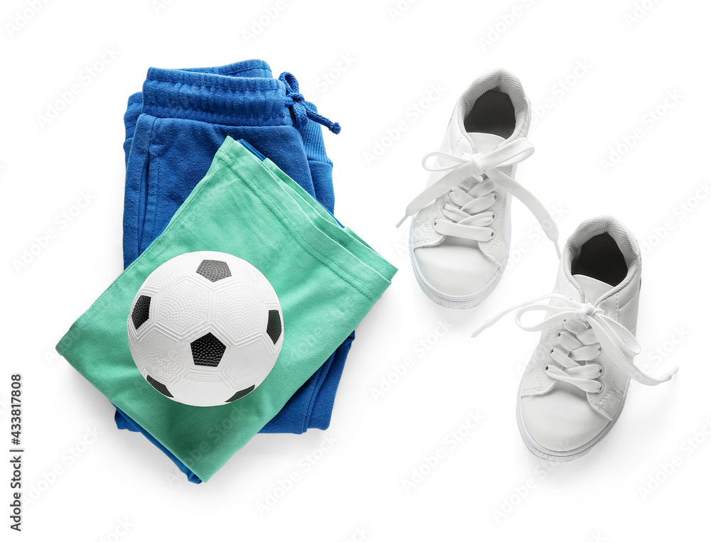 Childs clothes and ball on white background