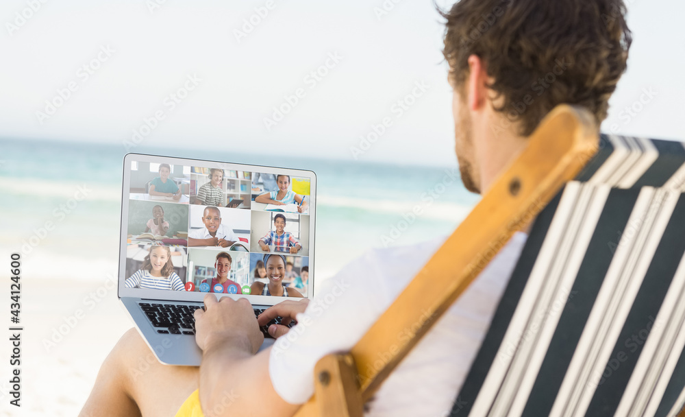白人男子在海滩上放松，用笔记本电脑进行视频通话