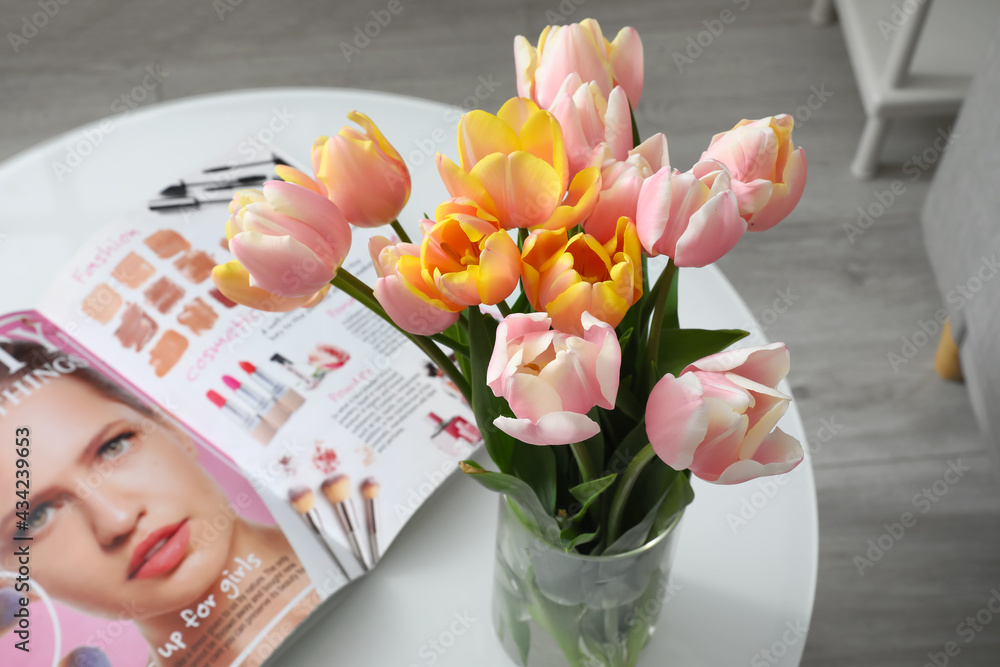房间桌子上的郁金香花束和杂志