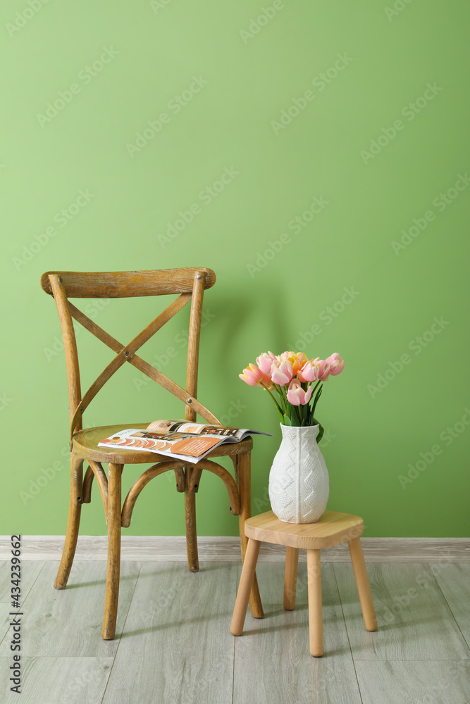 房间里靠近彩色墙壁的郁金香花和椅子的花束