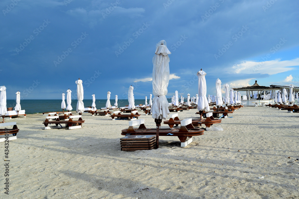 开放时间后（晚上）空的沙滩椅和雨伞-Navodari，Constanta，Dobrudja