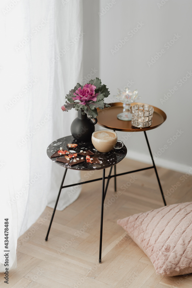 黑色桌子上的黑巧克力脆奶茶，上面有一朵观赏性的羽衣甘蓝花