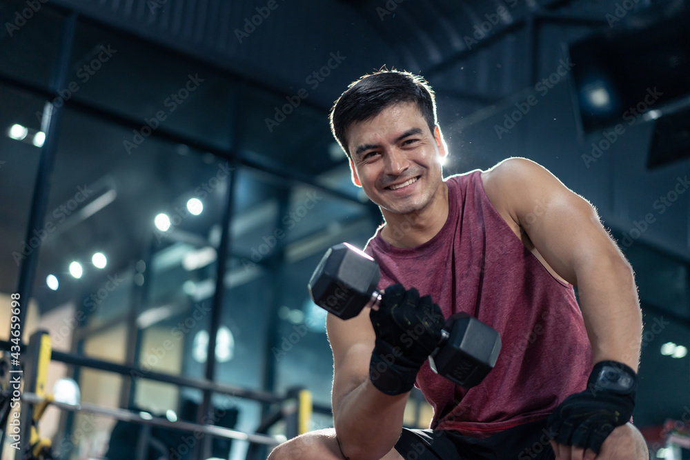 Portrait of Caucasian male athlete doing exercise by using dumbbell.