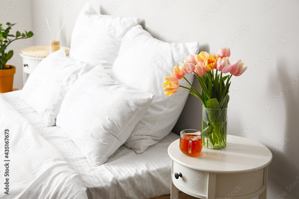 卧室桌子上的郁金香花和一杯茶