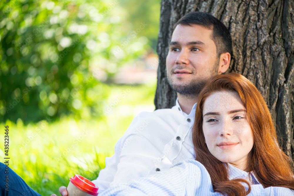 年轻夫妇在树下喝咖啡放松