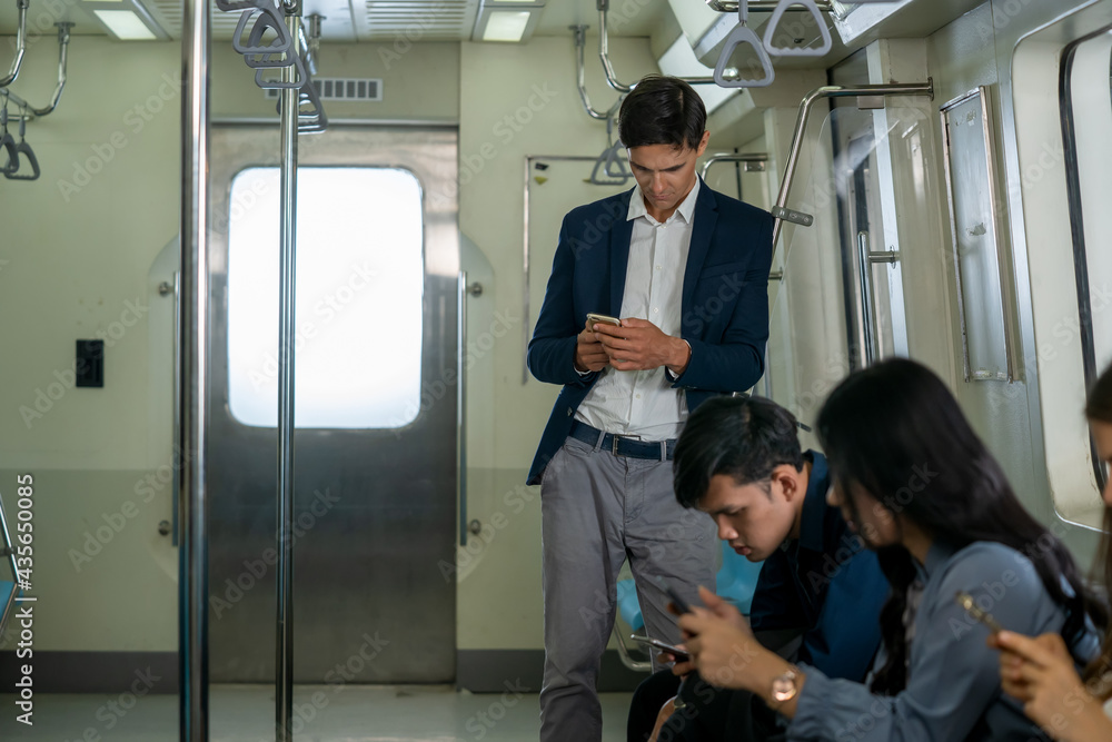 乘客在地铁列车上通过智能手机使用社交网络，列车上的人在旅途中