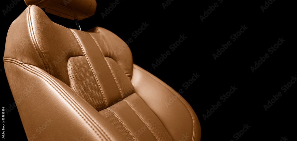 现代豪华汽车棕色皮革内饰。部分橙色皮革汽车座椅细节，带缝线。In