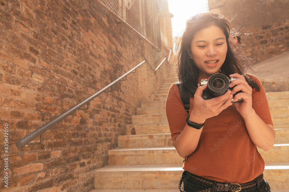 迷人的亚洲女性旅行者旅游手用相机观光车里的旧石头楼梯走廊