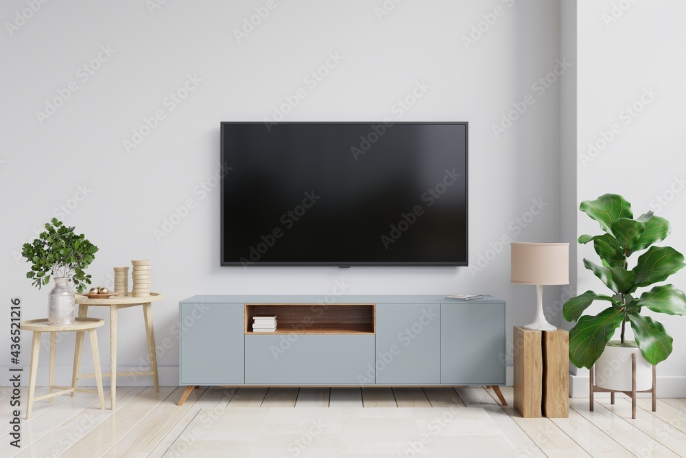 在一个有白墙的客厅里，模拟一个安装在橱柜上的电视墙。