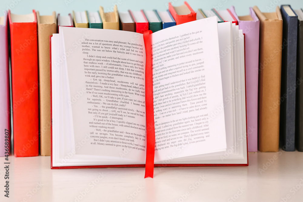 Open book with bookmark on color background