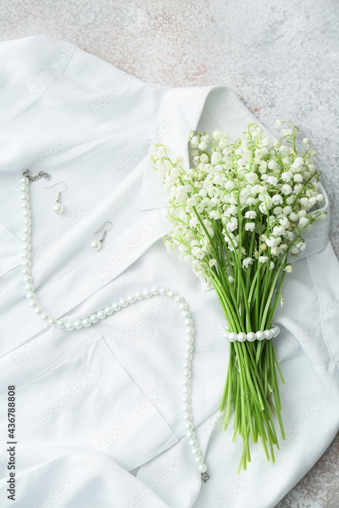 美丽的铃兰花朵、珠宝和浅色背景衬衫