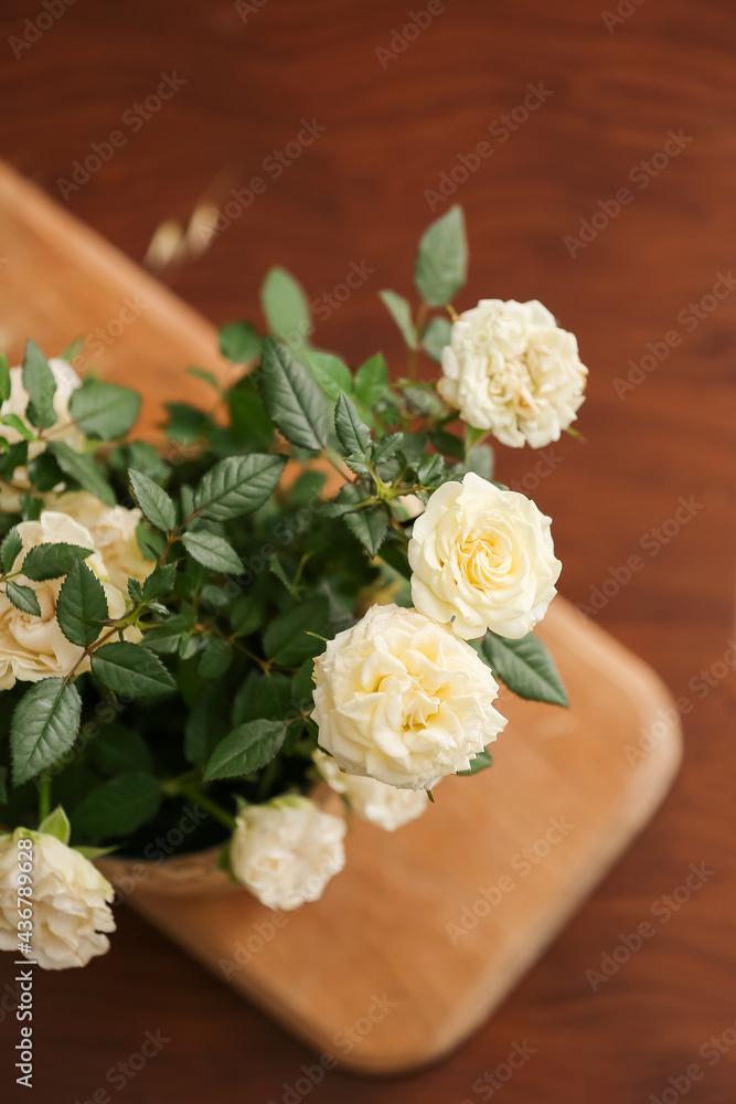美丽的白玫瑰在木制背景的花盆中