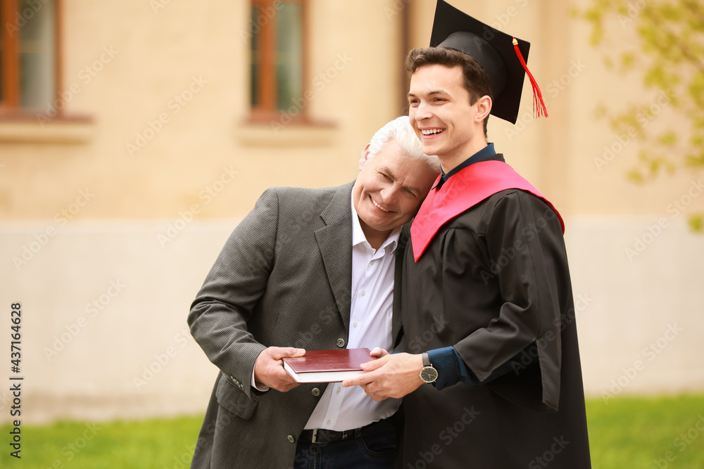 快乐的年轻人在毕业那天和他的父亲在一起