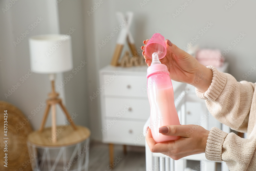 房间里有一瓶给婴儿的牛奶的女人