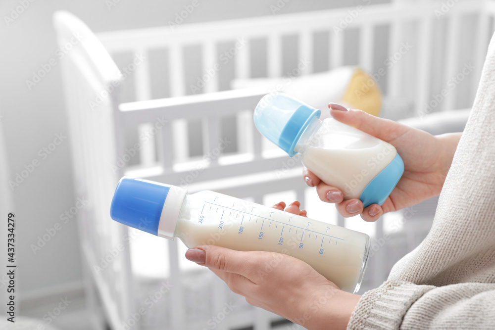 带着奶瓶给婴儿的女人，特写镜头