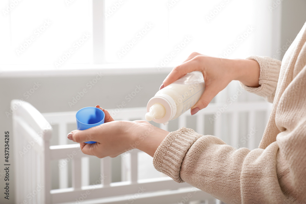 妇女检查婴儿配方奶粉的温度，特写