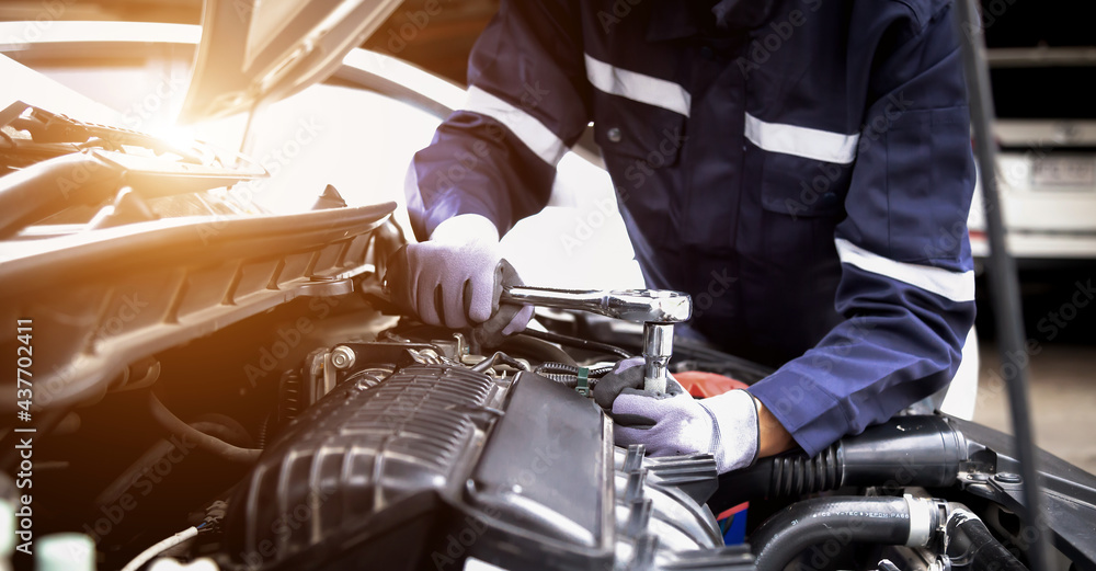 汽车修理工在修理厂修理汽车发动机。维修服务，汽车服务，修理，维护
