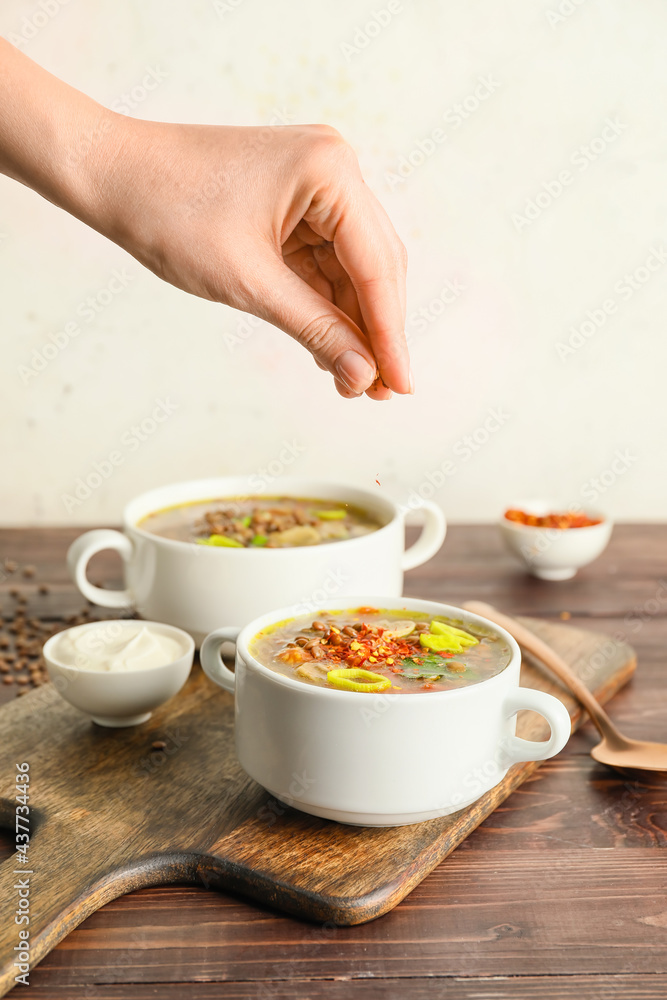 女人在锅里调味美味的扁豆汤