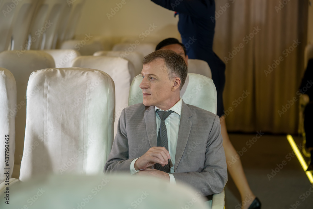 Confident professional businessman sitting in airplane,Business trip.