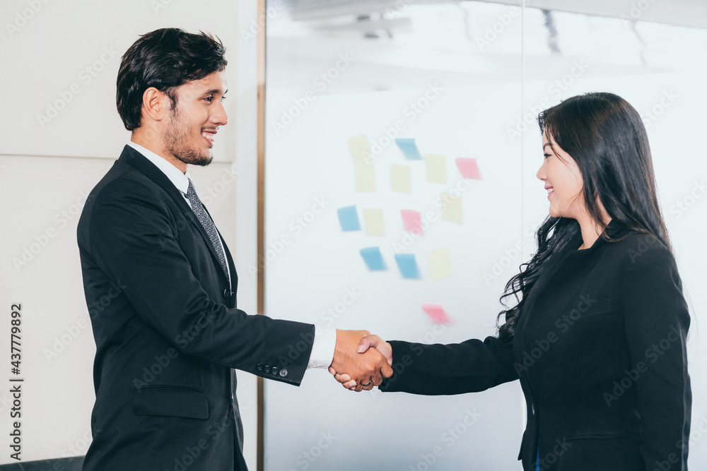 商务人士协议概念。商务人士和亚洲女商务人士在办公室握手。