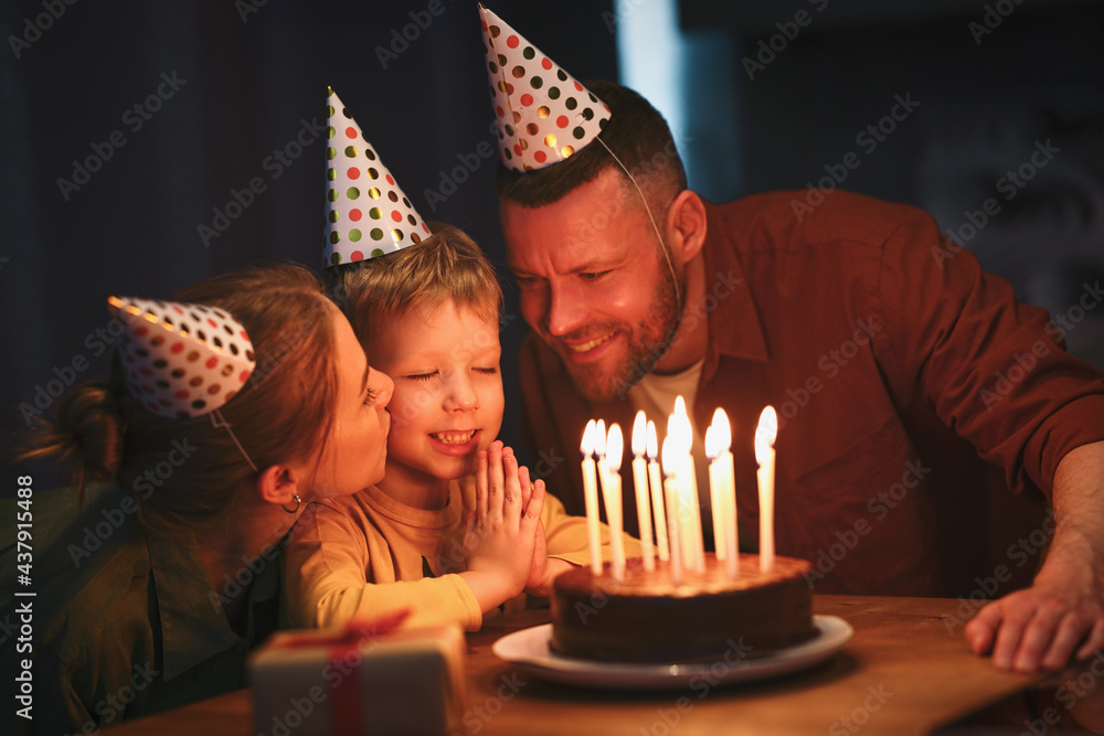 Cute little boy celebrating his birthday with loving parents at home
