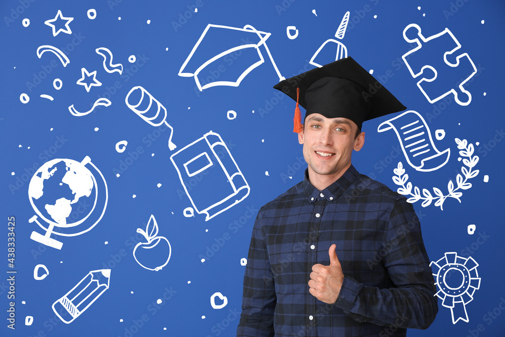 Young man in graduation hat showing thumb-up gesture on color background