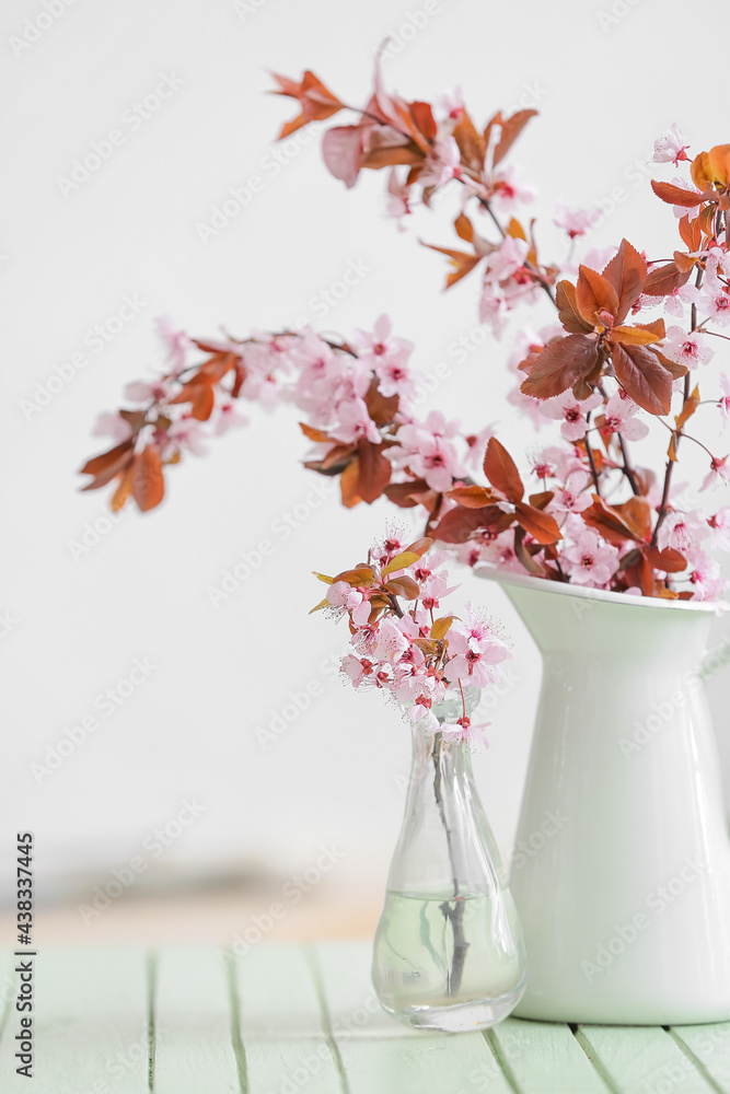 房间桌子上有漂亮的开花树枝的罐子和花瓶