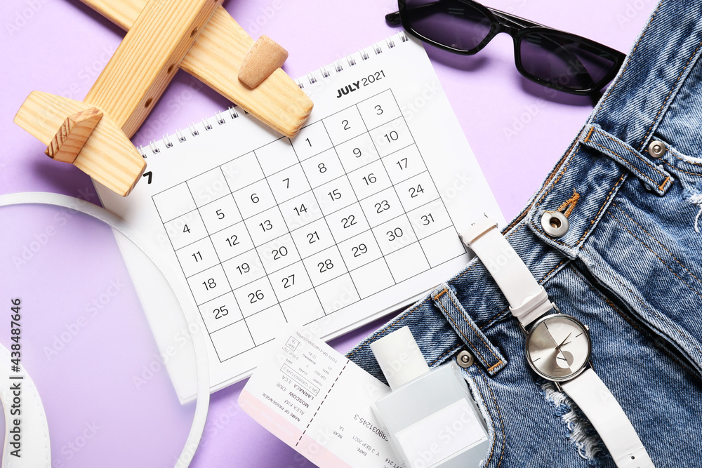 Calendar, ticket and travel accessories on color background, closeup