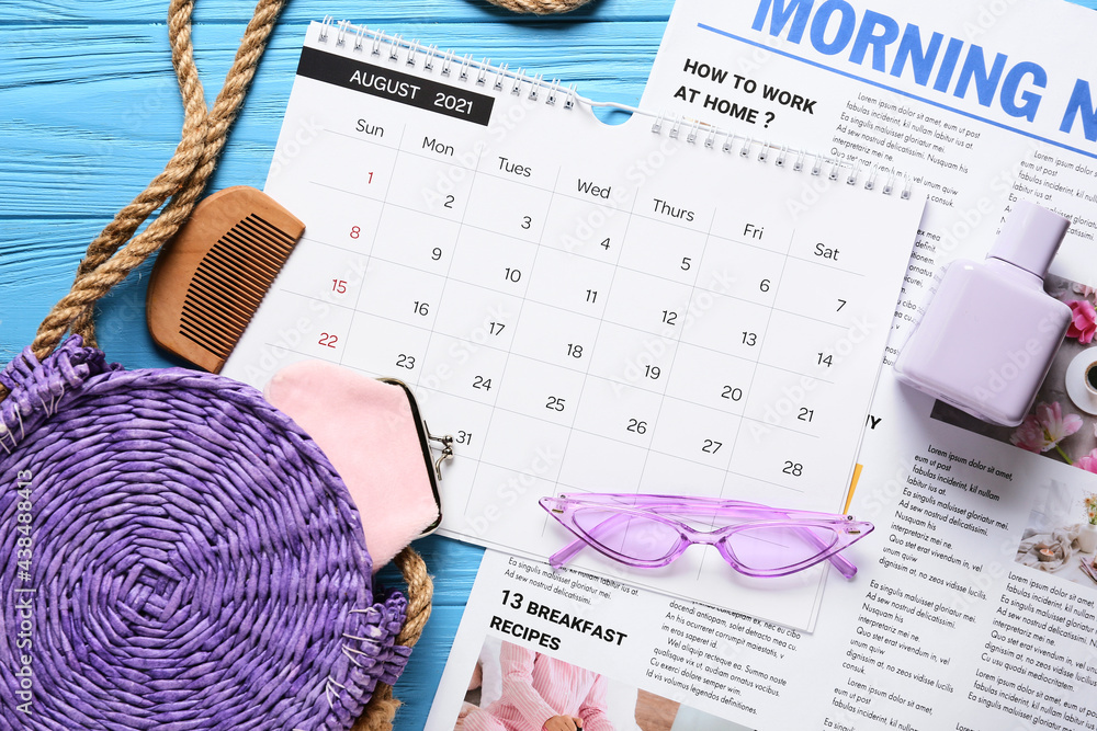 彩色木制背景上的日历、报纸和女性配饰，特写