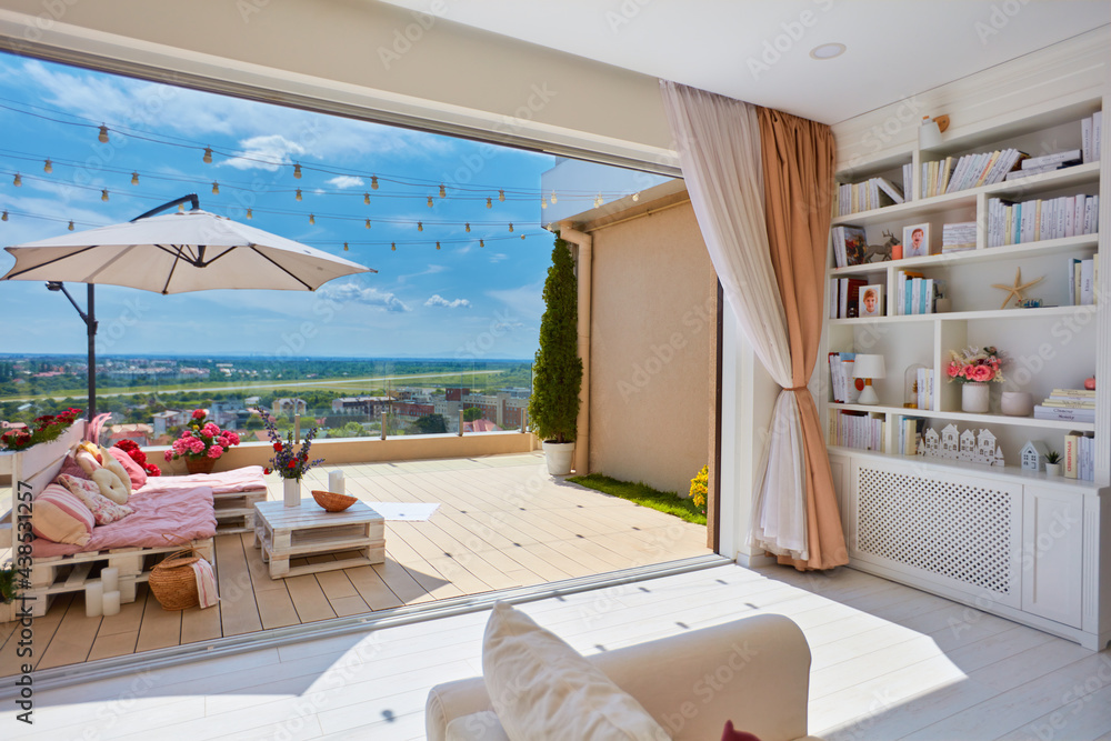 舒适的客厅，带开放空间的屋顶露台，装饰有五颜六色的木制托盘家具