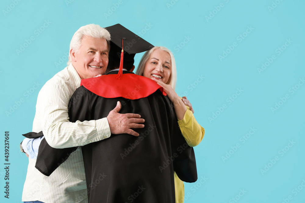 快乐的男毕业学生，和他的父母在彩色背景下
