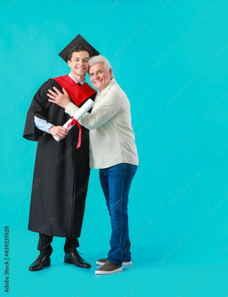 快乐的男毕业学生和他的父亲在彩色背景上