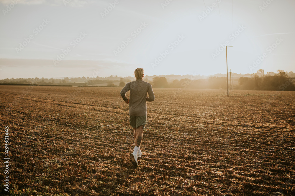 Active man in sportswear running in the countryside