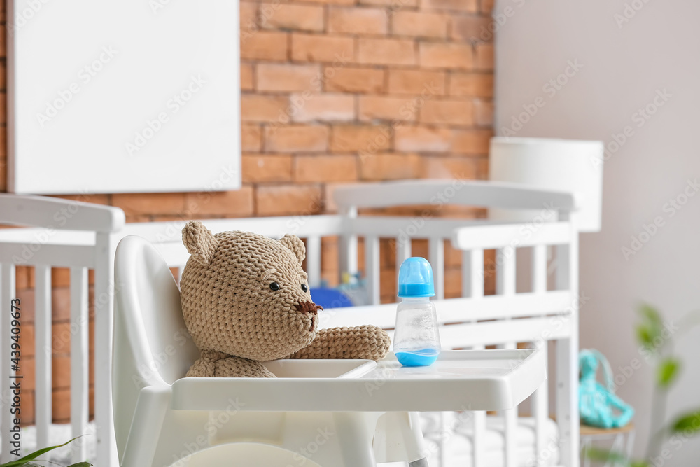 儿童卧室里有玩具和瓶子的喂食椅