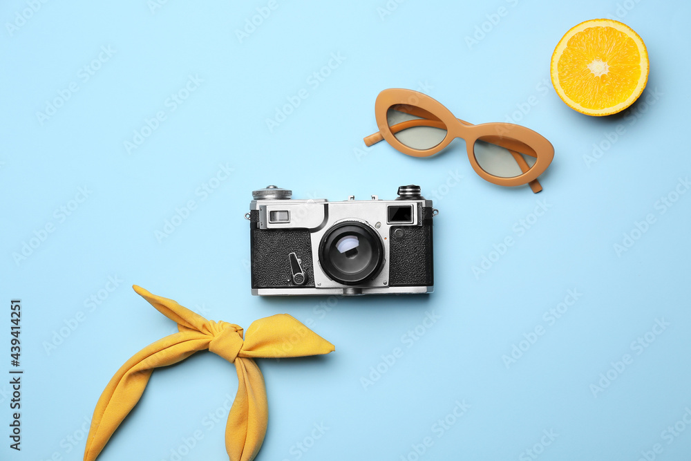 Female accessories, photo camera and orange on color background