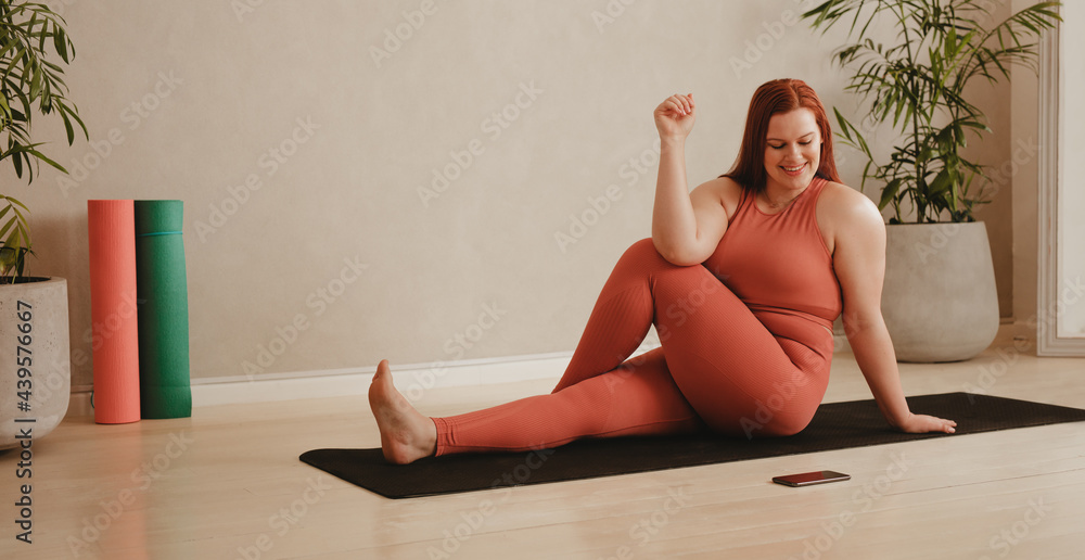 女性在做瑜伽时遵循手机指令