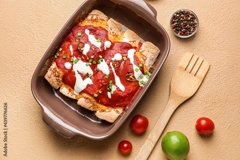 Baking dish with tasty cooked enchilada on color background