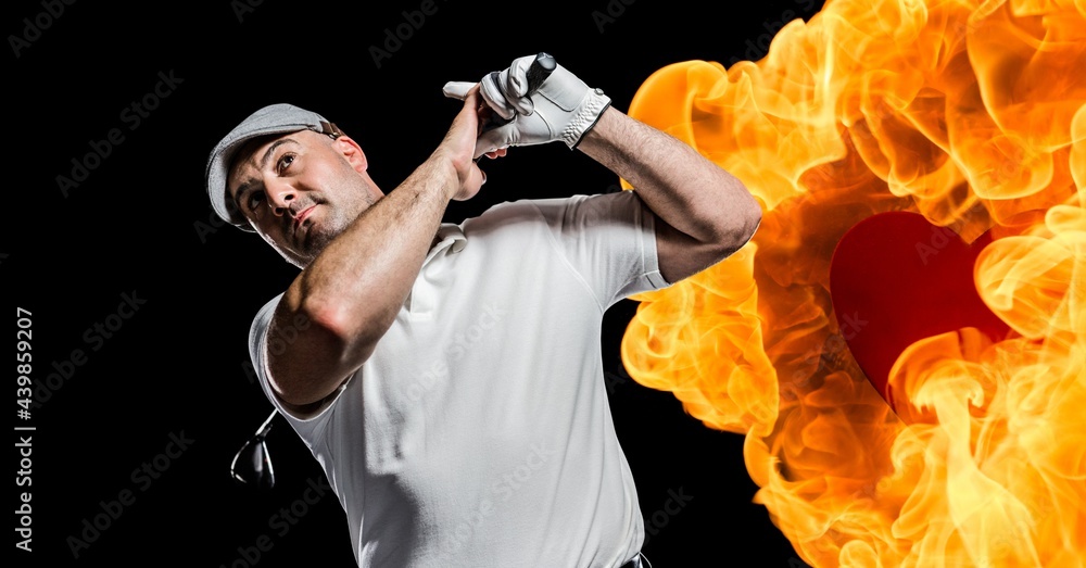 高加索人高级男子高尔夫球手在黑色背景下挥杆对抗火焰效应