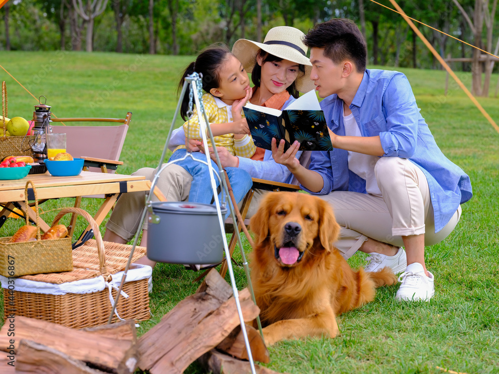 幸福的三口之家和宠物狗在外面读书