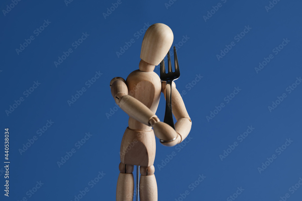 彩色背景带叉子的木制人体模型