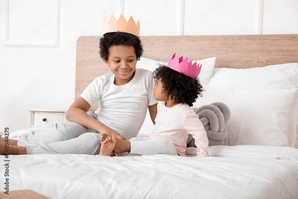 非裔美国儿童坐在房间的床上