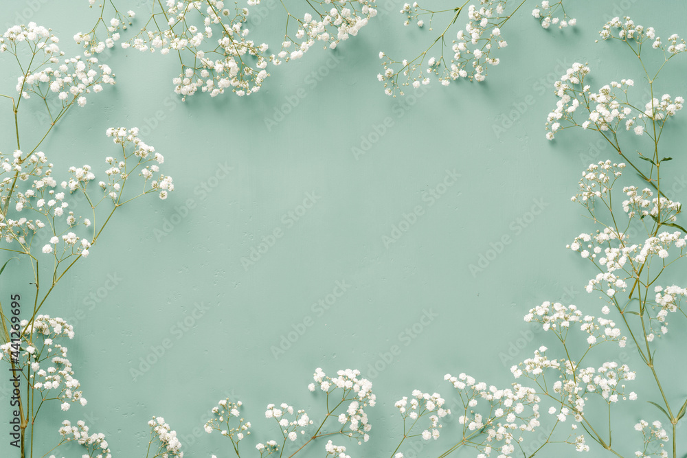 鲜花构图。绿松石蓝色背景上的白色花朵。带小花的婚礼模型。