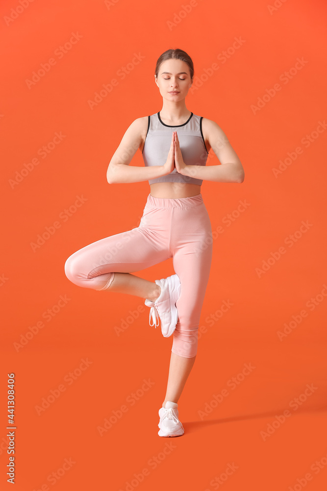 运动型年轻女子在彩色背景下做瑜伽