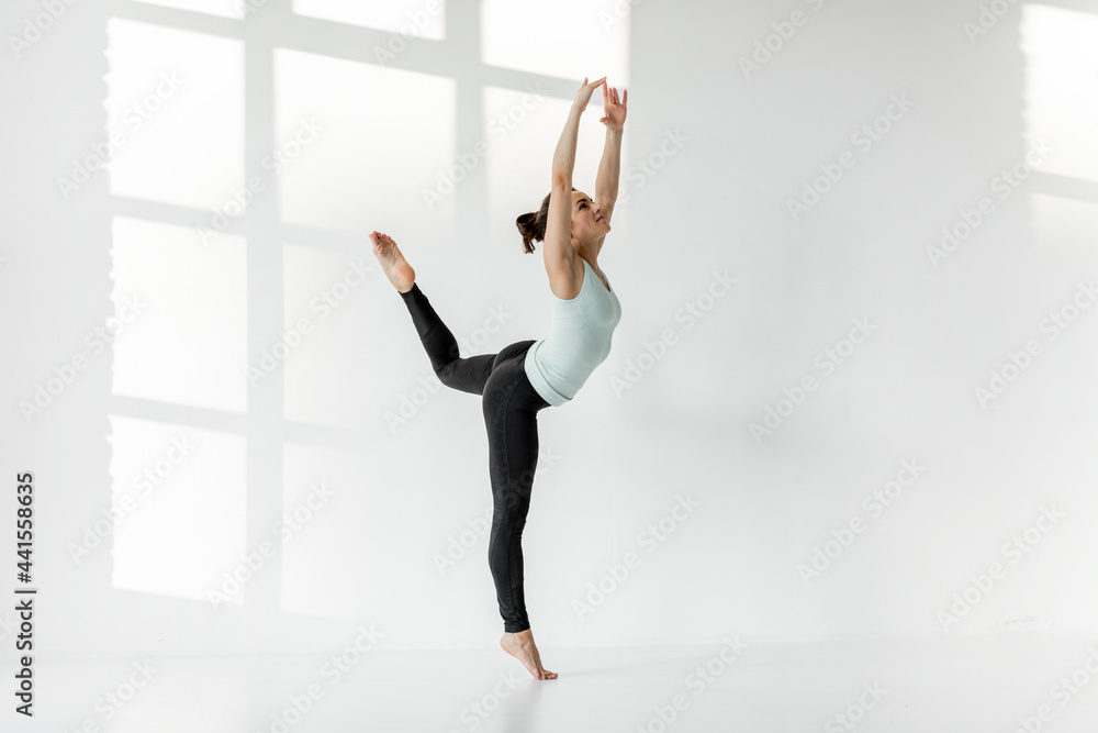 运动型女子独自在白人教室练习艺术体操或芭蕾舞